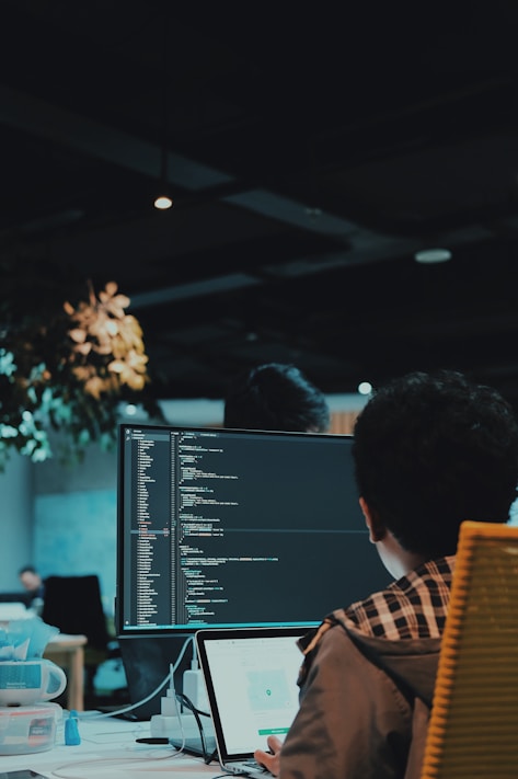 Developer coding on multiple screens representing digital innovation